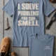 Funny Plumber Repair Graphic Tee "I Solve Problems You Can Smell" Back - "Plumbing Systems Diagnostician" Front — blue-jean — Flat-lay Funny Plumber Repair Graphic Tee "I Solve Problems You Can Smell" Back - "Plumbing Systems Diagnostician" Front — blue-jean t-shirt, flat-lay product photo | Pressure Tested Co