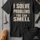 Funny Plumber Repair Graphic Tee "I Solve Problems You Can Smell" Back - "Plumbing Systems Diagnostician" Front — blue-spruce — Flat-lay Funny Plumber Repair Graphic Tee "I Solve Problems You Can Smell" Back - "Plumbing Systems Diagnostician" Front — blue-spruce t-shirt, flat-lay product photo | Pressure Tested Co