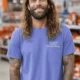 Funny Plumber Repair Graphic Tee "I Solve Problems You Can Smell" Back - "Plumbing Systems Diagnostician" Front — flo-blue — Model Funny Plumber Repair Graphic Tee "I Solve Problems You Can Smell" Back - "Plumbing Systems Diagnostician" Front — flo-blue t-shirt, model photo | Pressure Tested Co