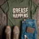 Grease Happens T-Shirt — Funny Mechanic Garage Tee — military-green — Flat-lay Grease Happens T-Shirt — Funny Mechanic Garage Tee — military-green t-shirt, flat-lay product photo | Pressure Tested Co