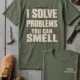 Funny Plumber Repair Graphic Tee "I Solve Problems You Can Smell" Back - "Plumbing Systems Diagnostician" Front — moss — Flat-lay Funny Plumber Repair Graphic Tee "I Solve Problems You Can Smell" Back - "Plumbing Systems Diagnostician" Front — moss t-shirt, flat-lay product photo | Pressure Tested Co