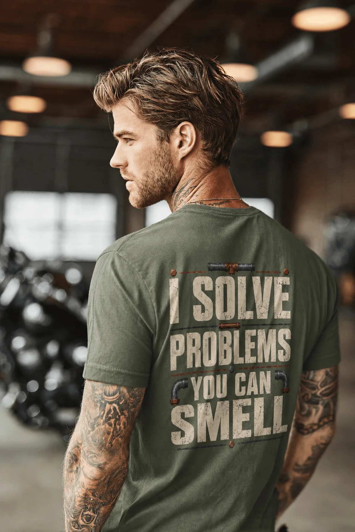 Funny Plumber Repair Graphic Tee "I Solve Problems You Can Smell" Back - "Plumbing Systems Diagnostician" Front — moss — Model Funny Plumber Repair Graphic Tee "I Solve Problems You Can Smell" Back - "Plumbing Systems Diagnostician" Front — moss t-shirt, model photo | Pressure Tested Co