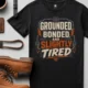Grounded, Bonded and Slightly Tired Graphic Tee — Funny Electrical Worker Shirt — black t-shirt, flat-lay product photo | Pressure Tested Co