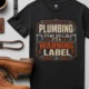 Plumbing Warning Label T-Shirt — Funny Plumber Shirt — black t-shirt, flat-lay product photo | Pressure Tested Co