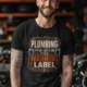 Plumbing Warning Label T-Shirt — Funny Plumber Shirt — black t-shirt, model photo | Pressure Tested Co