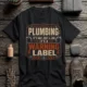 Plumbing Warning Label T-Shirt — Funny Plumber Shirt — dark-grey t-shirt, flat-lay product photo | Pressure Tested Co