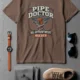 Plumber T-Shirt — "Pipe Doctor. No Appointment Needed" Vintage Work Shirt — espresso — Flat-lay Plumber T-Shirt — "Pipe Doctor. No Appointment Needed" Vintage Work Shirt — espresso t-shirt, flat-lay product photo | Pressure Tested Co