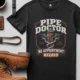 Plumber T-Shirt — "Pipe Doctor. No Appointment Needed" Vintage Work Shirt — graphite — Flat-lay Plumber T-Shirt — "Pipe Doctor. No Appointment Needed" Vintage Work Shirt — graphite t-shirt, flat-lay product photo | Pressure Tested Co