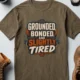 Grounded, Bonded and Slightly Tired Graphic Tee — Funny Electrical Worker Shirt — heather-olive t-shirt, flat-lay product photo | Pressure Tested Co