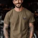 Wrench First Tee — "Wrench First, Questions Later" Mechanic Skull T-Shirt — heather-olive t-shirt, model photo | Pressure Tested Co