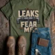Leaks Fear Me T-Shirt - Funny Plumber Pipes Tee — military-green t-shirt, flat-lay product photo | Pressure Tested Co