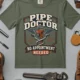 Plumber T-Shirt — "Pipe Doctor. No Appointment Needed" Vintage Work Shirt — moss — Flat-lay Plumber T-Shirt — "Pipe Doctor. No Appointment Needed" Vintage Work Shirt — moss t-shirt, flat-lay product photo | Pressure Tested Co