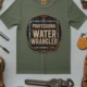 Funny Plumber Tee - "Professional Water Wrangler" Rustic Rope Graphic T-Shirt — moss t-shirt, flat-lay product photo | Pressure Tested Co