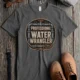 Funny Plumber Tee - "Professional Water Wrangler" Rustic Rope Graphic T-Shirt — pepper t-shirt, flat-lay product photo | Pressure Tested Co