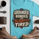 Grounded, Bonded and Slightly Tired Graphic Tee — Funny Electrical Worker Shirt — turquoise t-shirt, flat-lay product photo | Pressure Tested Co