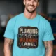 Plumbing Warning Label T-Shirt — Funny Plumber Shirt — turquoise t-shirt, model photo | Pressure Tested Co