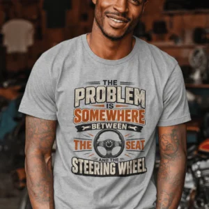 Driving Humor T-Shirt — "The Problem Is Somewhere Between The Seat And The Steering Wheel" — athletic-heather t-shirt, model photo | Pressure Tested Co