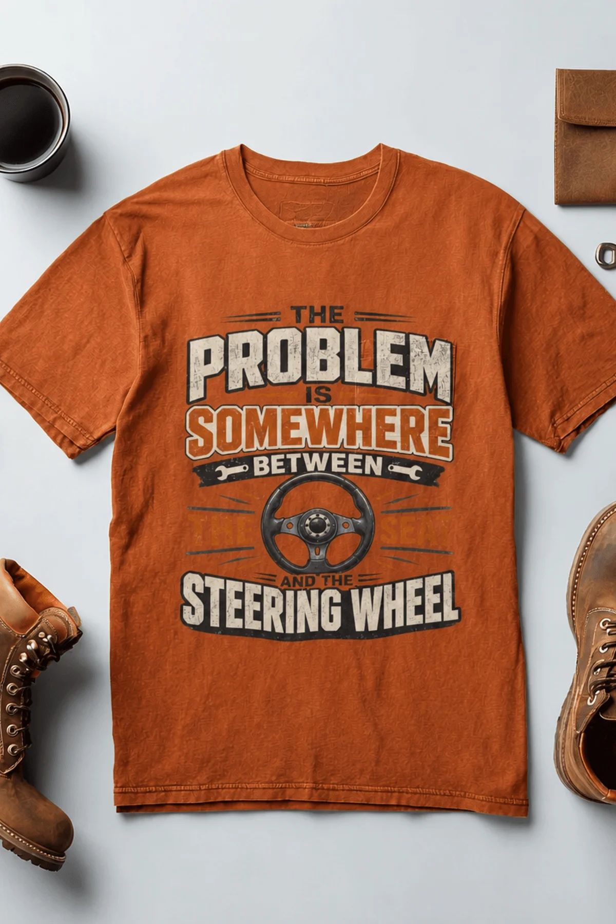 Driving Humor T-Shirt — "The Problem Is Somewhere Between The Seat And The Steering Wheel" — autumn t-shirt, flat-lay product photo | Pressure Tested Co