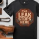 "The Leak Stops Here" Stop Sign Badge Style — Plumbing Repair Tech Humorous Tee — black t-shirt, flat-lay product photo | Pressure Tested Co
