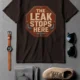 "The Leak Stops Here" Stop Sign Badge Style — Plumbing Repair Tech Humorous Tee — brown t-shirt, flat-lay product photo | Pressure Tested Co