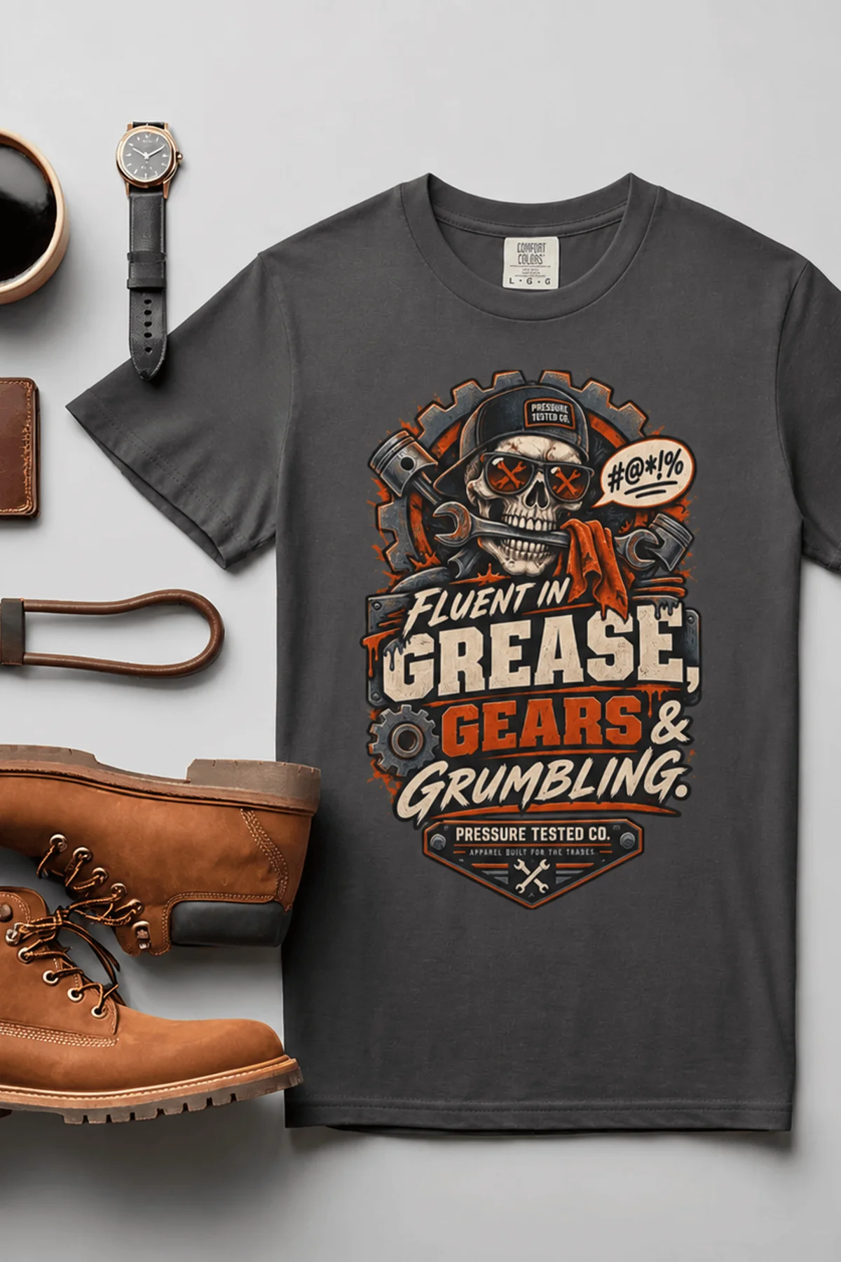 Mechanic Skull T-Shirt — "Fluent in Grease, Gears and Grumbling" Graphic Tee — graphite t-shirt, flat-lay product photo | Pressure Tested Co