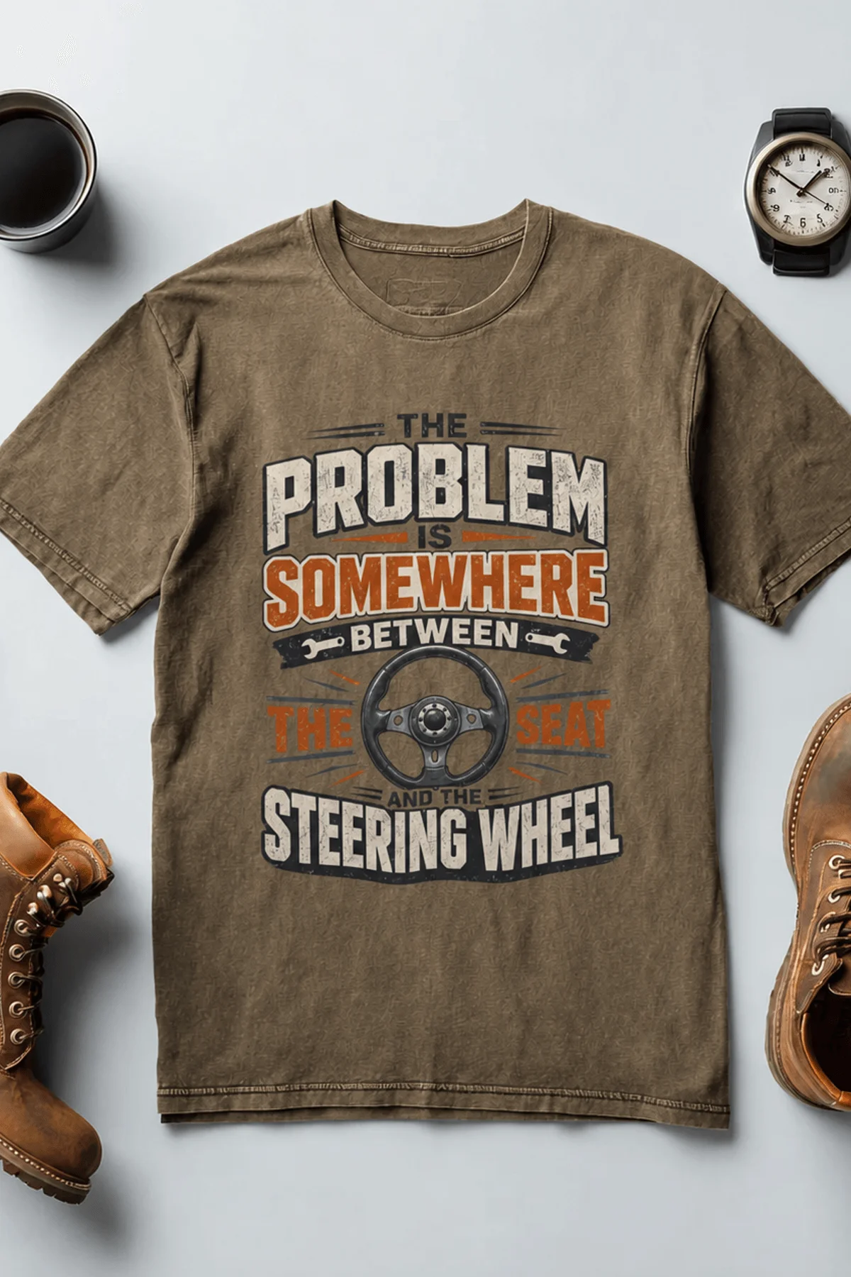 Driving Humor T-Shirt — "The Problem Is Somewhere Between The Seat And The Steering Wheel" — heather-olive t-shirt, flat-lay product photo | Pressure Tested Co
