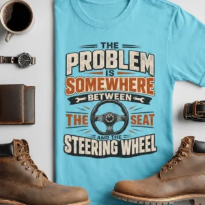 Driving Humor T-Shirt — "The Problem Is Somewhere Between The Seat And The Steering Wheel" — turquoise t-shirt, flat-lay product photo | Pressure Tested Co